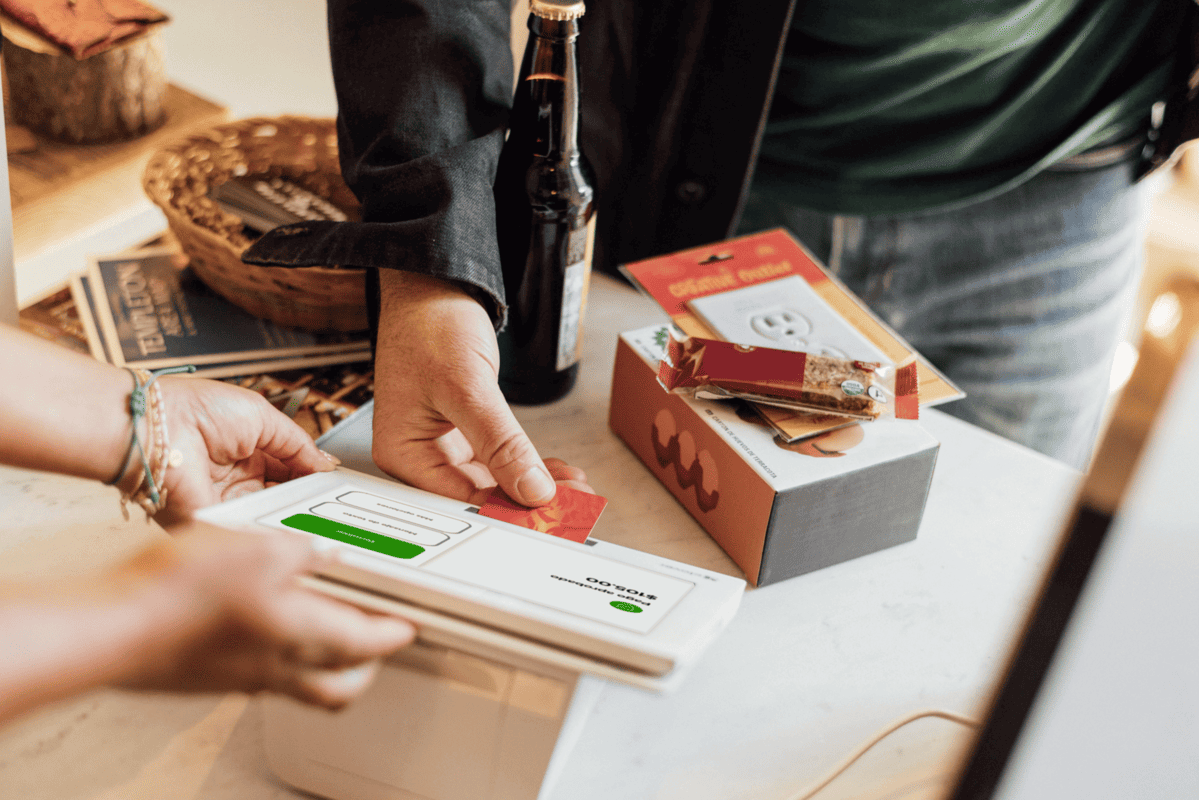 Dos personas en una caja registradora completan una transacción con tarjeta